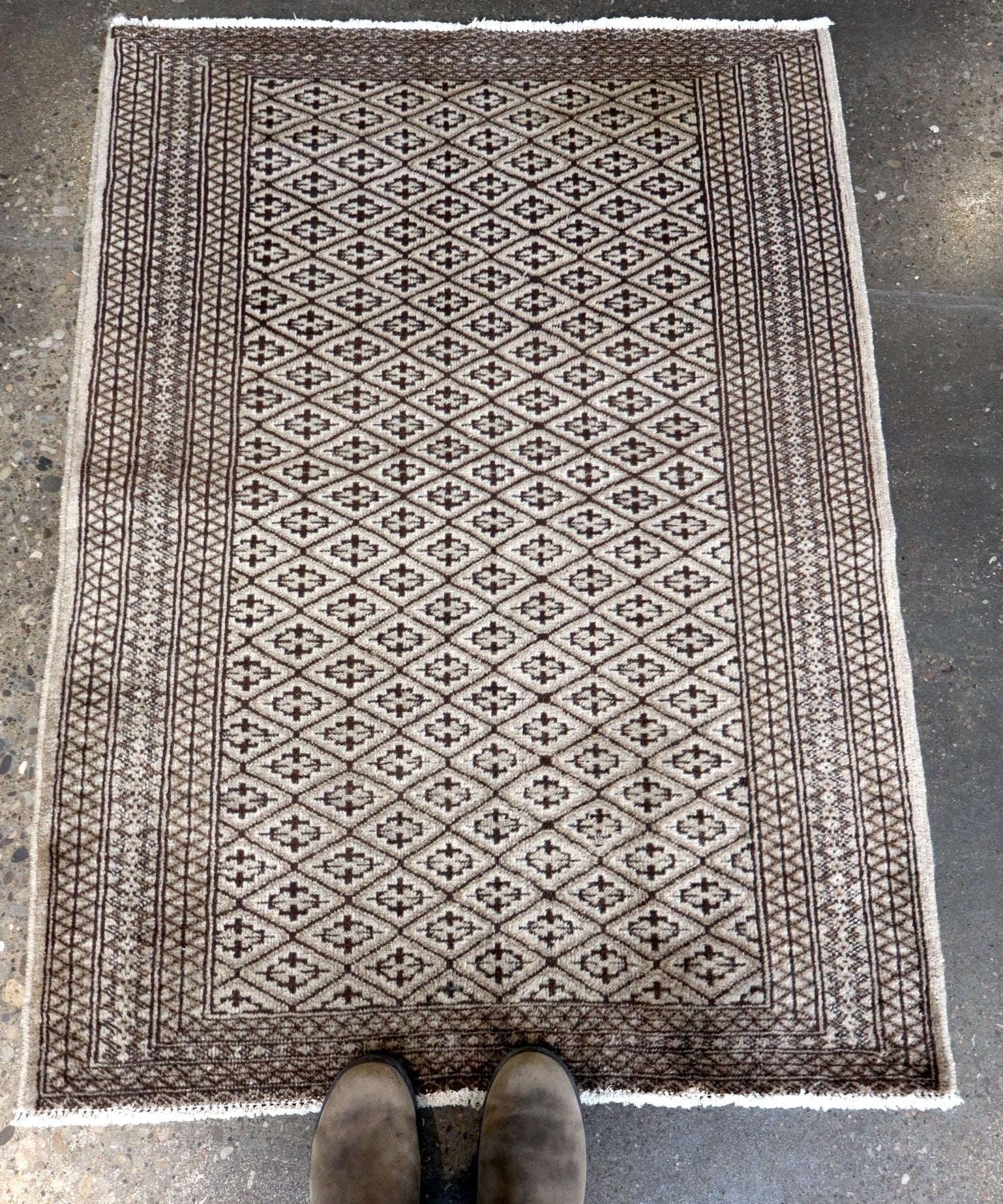 Persian Turkmen rug with centered diamond pattern, bordered edges, and fringe