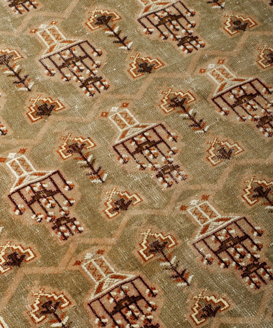 Close-up Turkmen rug showing geometric crosses and diamond motifs in rust, cream, and dark brown