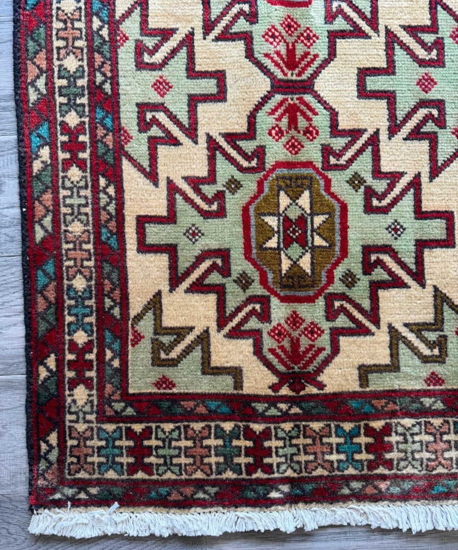 Persian Turkomana rug detail: cream ground with red, blue, and green zigzag motifs