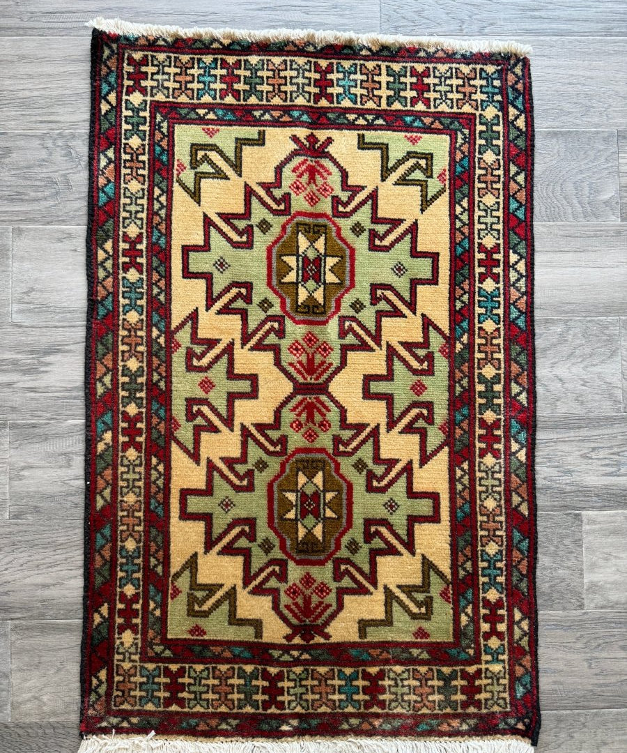Persian Turkomana rug with cream field, red border, and geometric medallion motifs