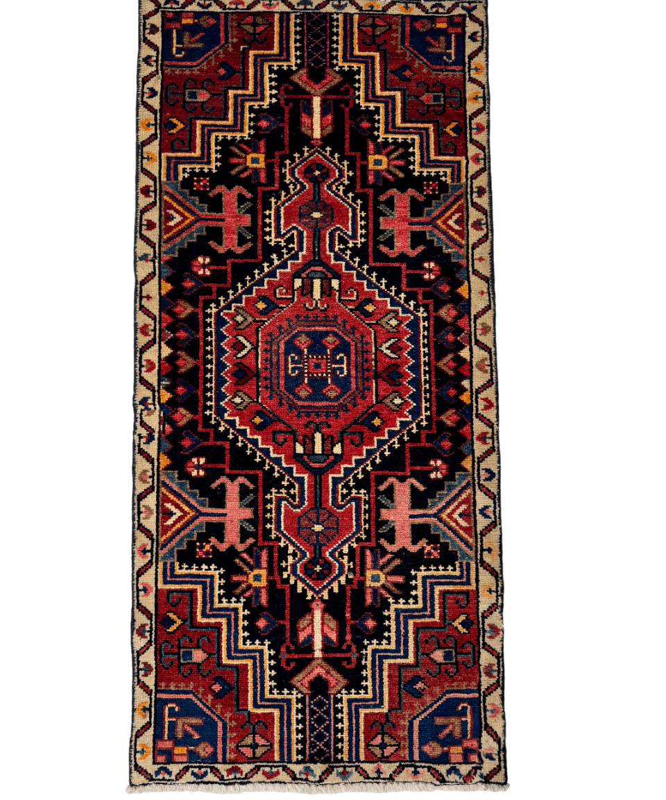 Persian-style area rug with red, navy, and cream geometric border and center design