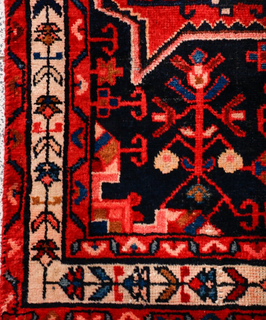 Tuyserkan Persian rug border close-up with navy, red, and cream pattern