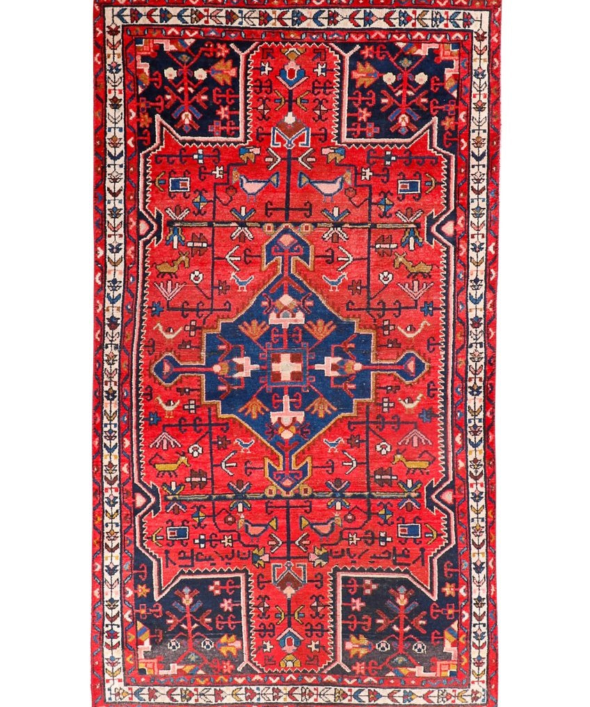 Tuyserkan Persian rug with red field, navy medallion, and cream geometric border