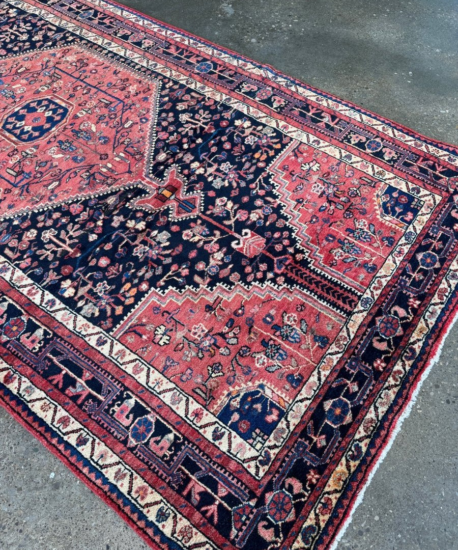 Persian-style area rug, top view, navy and red panels with cream borders and repeating geometric bands