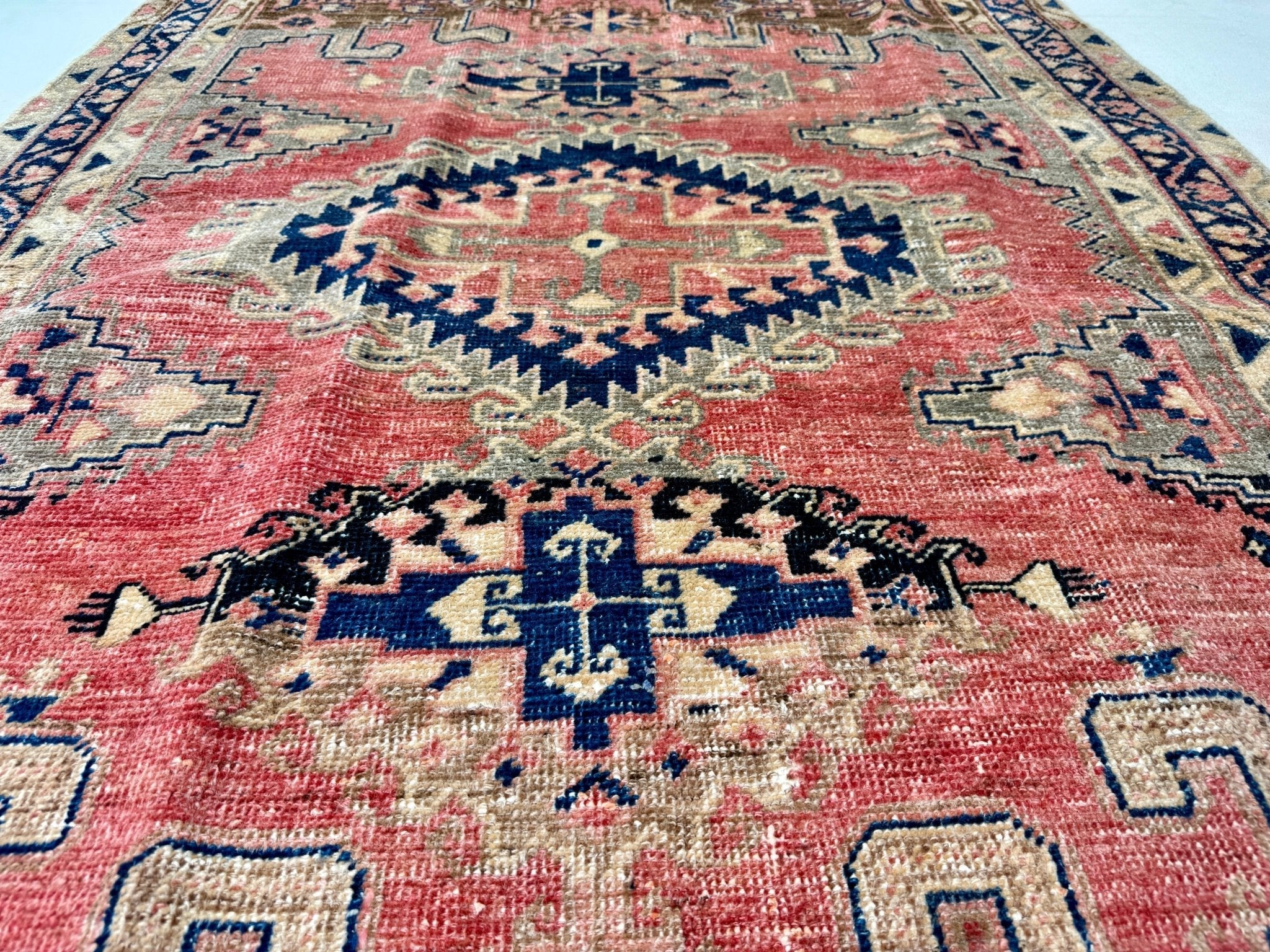 Close-up rug section in red with navy and cream star medallion motifs.