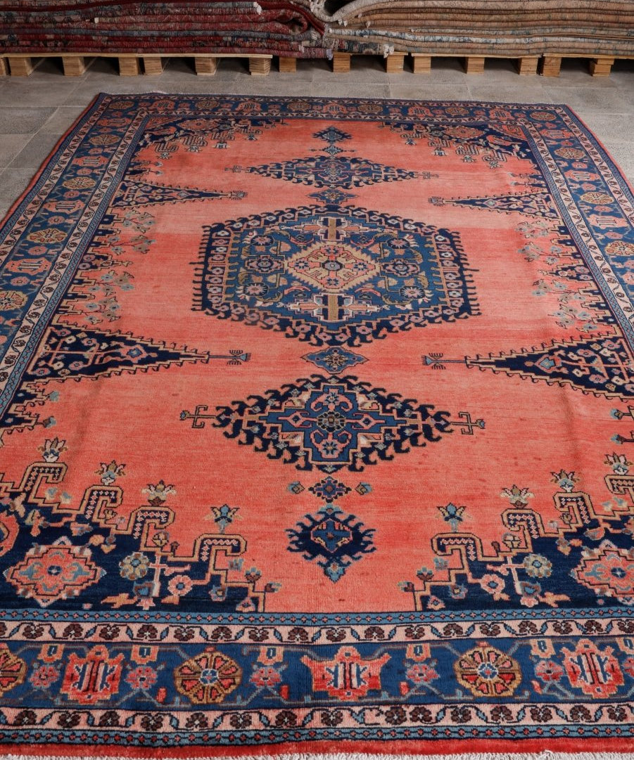 Persian rug, coral-red and navy geometric medallion, stitched border, 7'9" x 11'6"