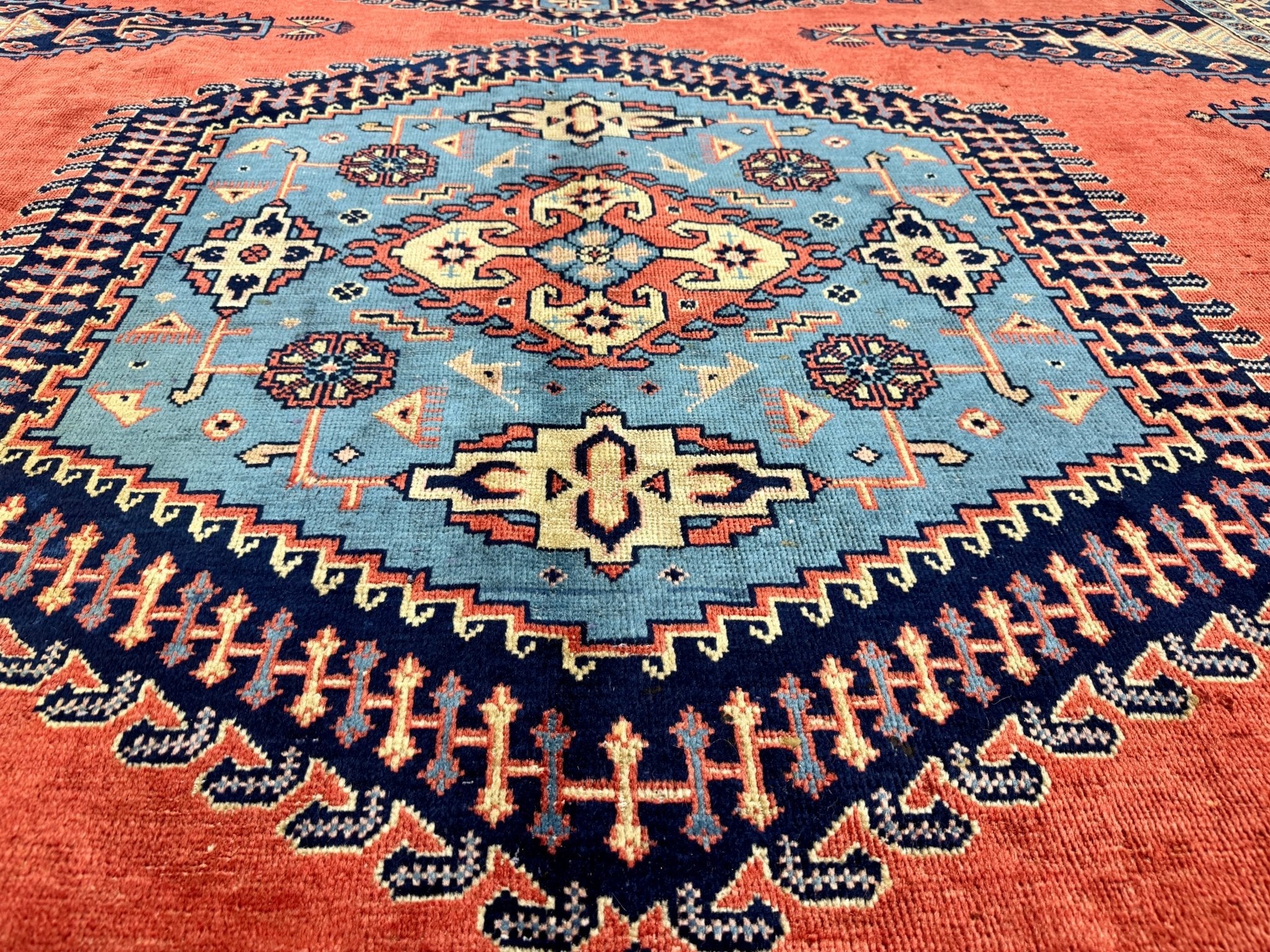 Persian Viss rug medallion close-up, red weave with navy and blue floral motifs