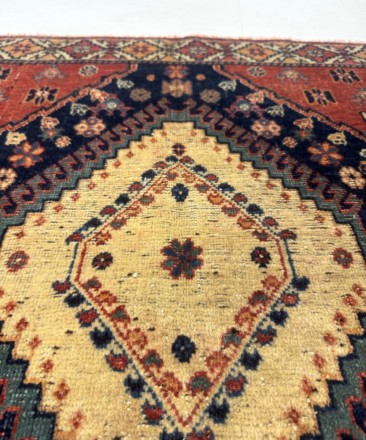 Persian Yalameh rug center medallion in cream on navy with red lattice trim