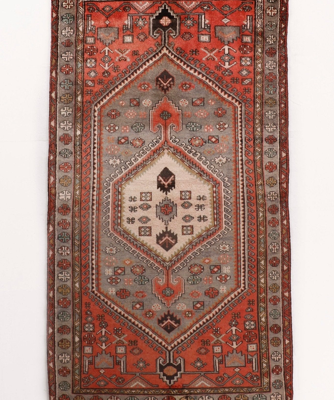 Whole red Persian Zanjan rug with central medallion and geometric border
