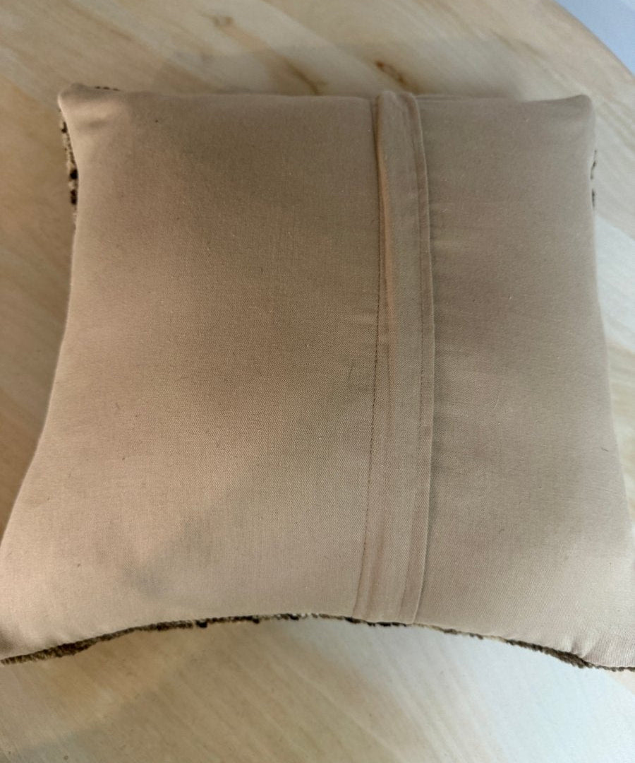 Beige square pillow back with matching seam lines and stitched edge finish.