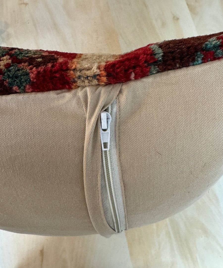 Beige square pillow side with zipper closure and multicolor woven trim