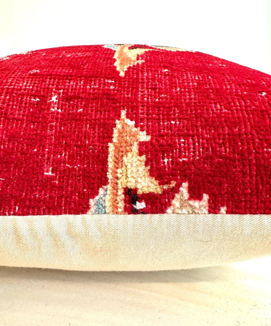 Red embroidered decorative pillow with beige edge trim, square close-up view.