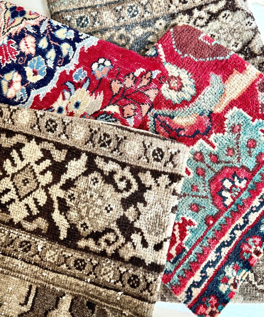Decorative pillows stacked, beige navy and red embroidered geometric floral patterns.
