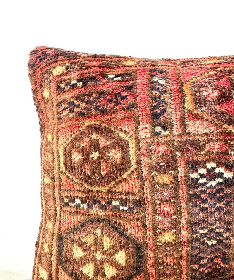 12 x 18 inch decorative pillow close-up with red, black, tan and cream circular motifs