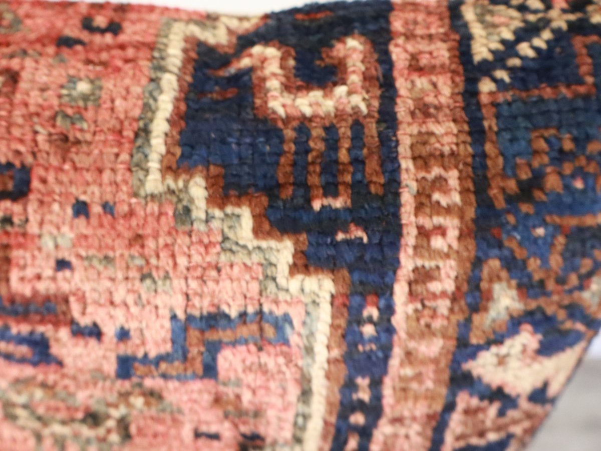 Closeup of woven geometric pillow fabric in rust, navy, and cream with textured fibers