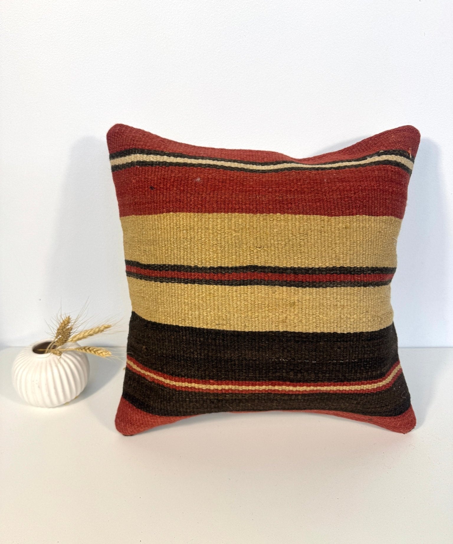 Striped 16x16 pillow with red, beige, yellow and dark gray horizontal bands