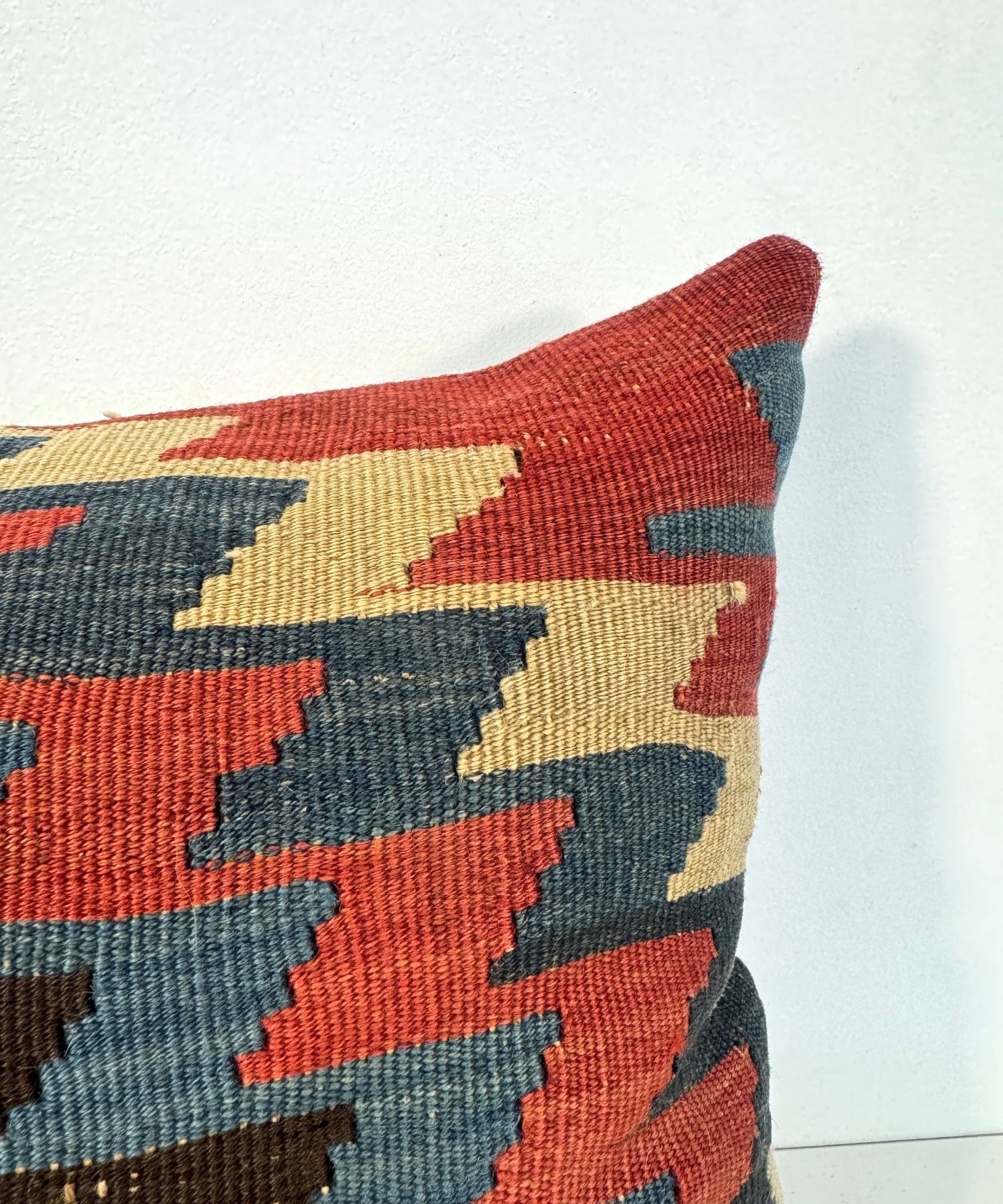 Decorative 16 x 16 pillow with red, blue, and beige geometric woven front.