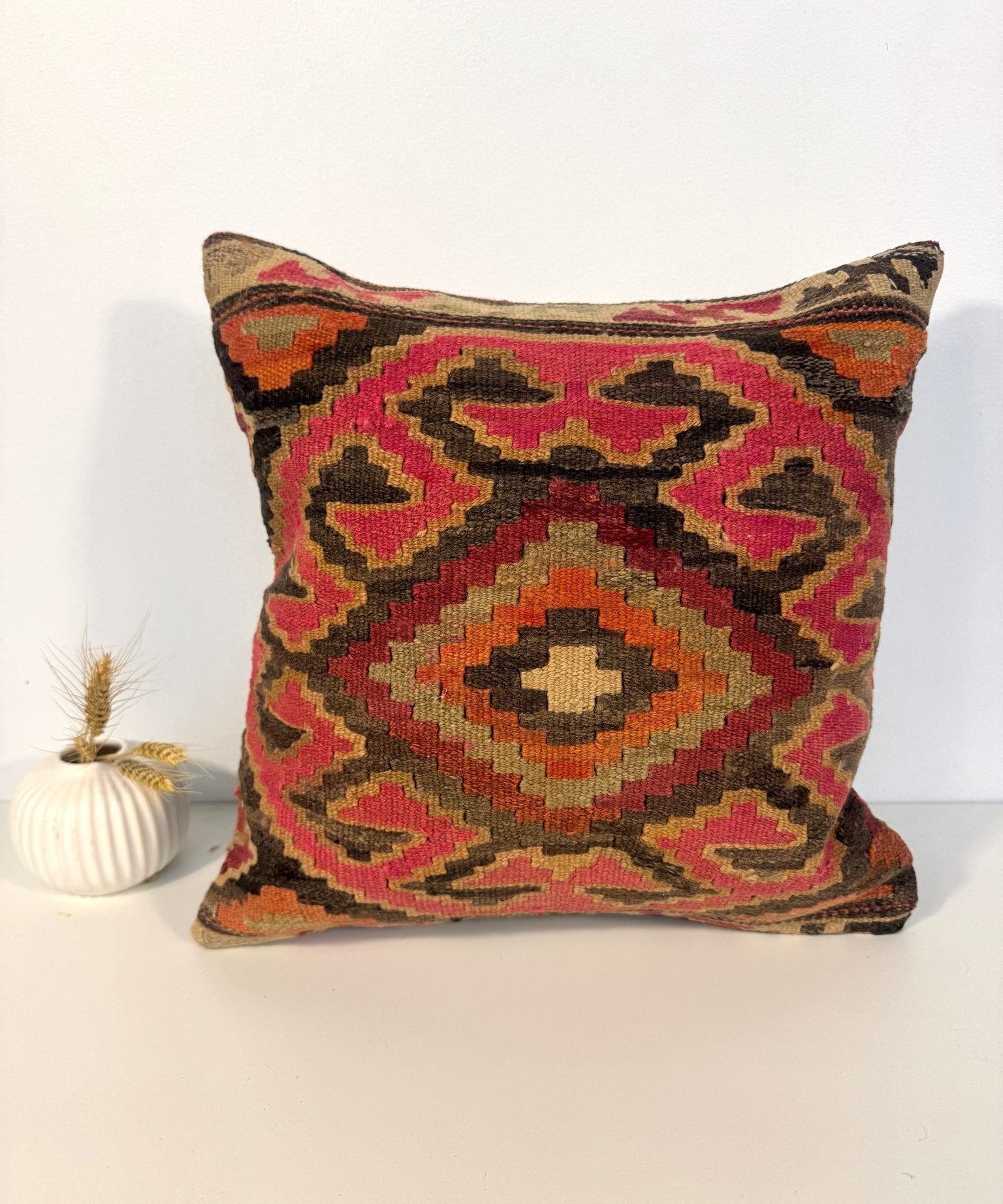Square kilim pillow cover featuring a symmetrical multicolor diamond pattern on the front.