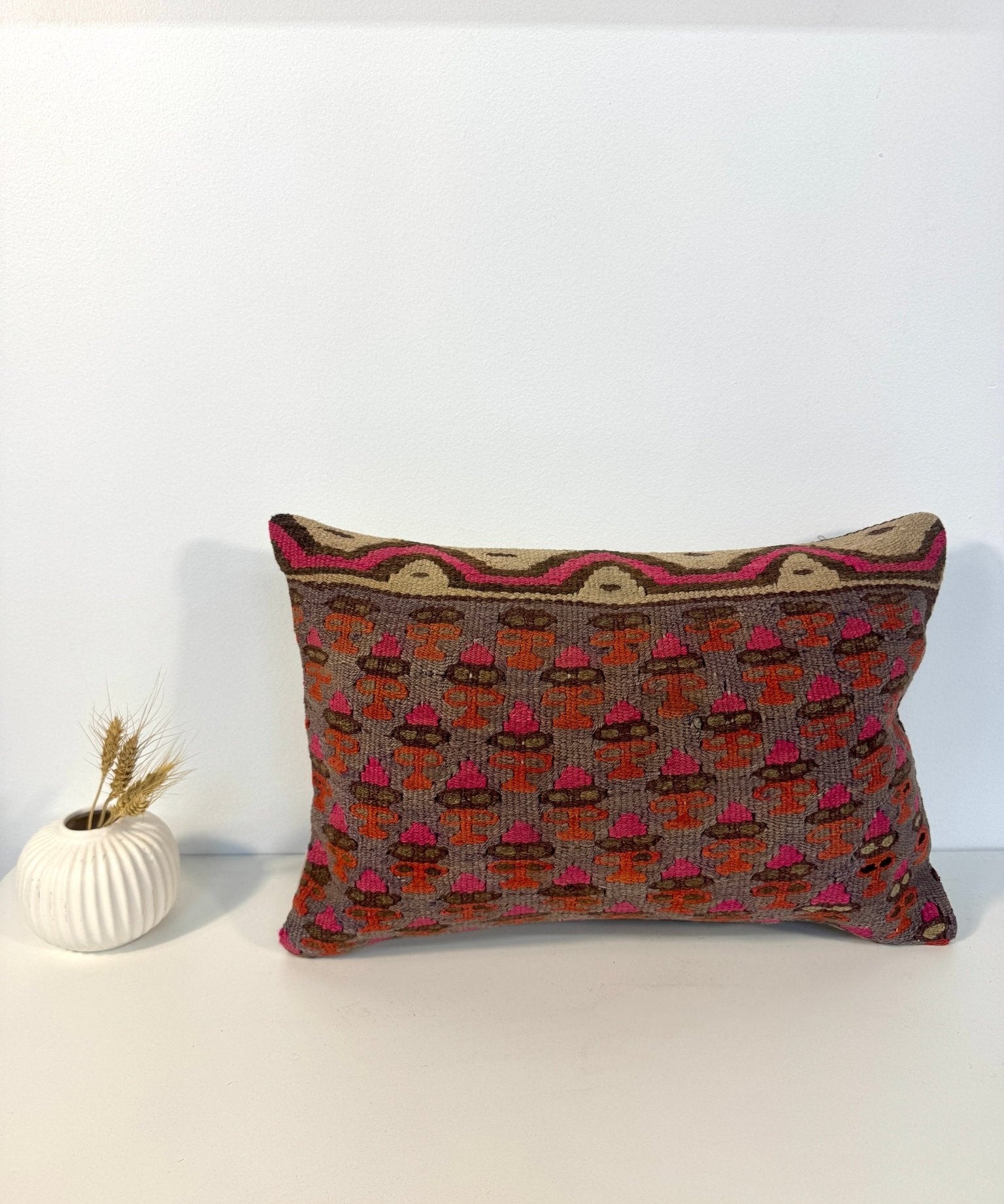 Rectangular embroidered throw pillow, gray with orange and pink geometric pattern