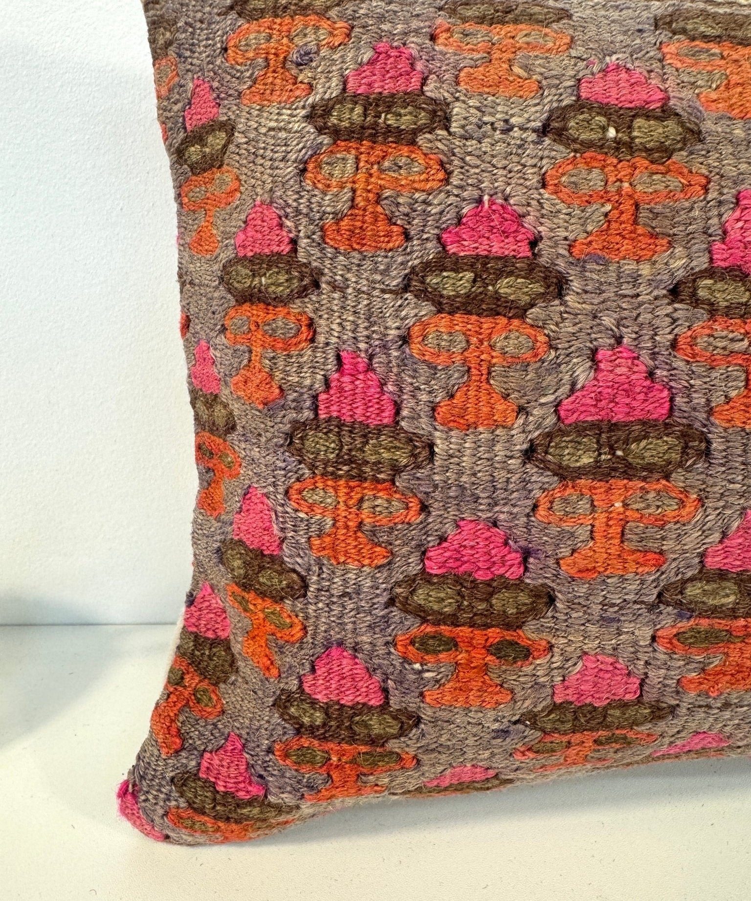 Rectangular embroidered pillow, gray base with orange and pink motif pattern and border