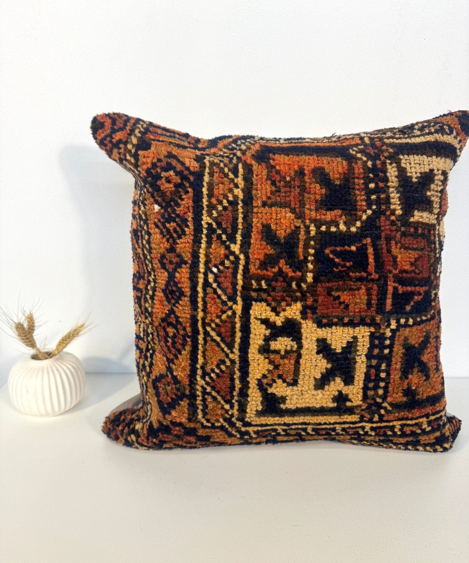 18 x 18 woven decorative pillow with geometric pattern in navy, orange, and yellow