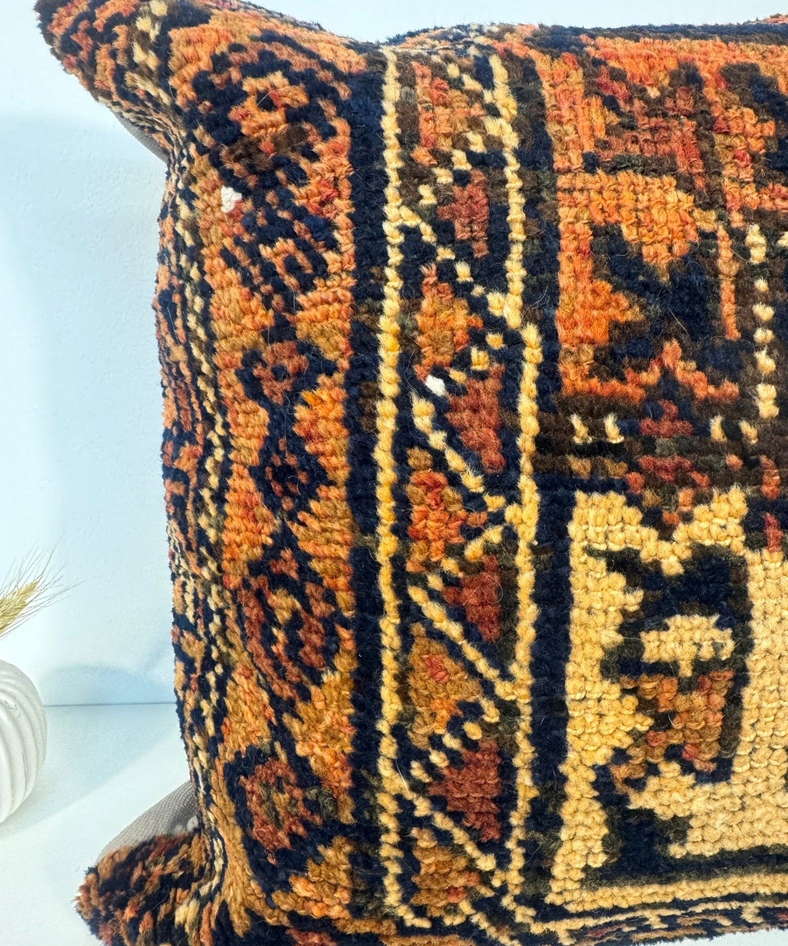 18 x 18 woven pillow showing geometric motif and textured yarn in navy, orange, and cream