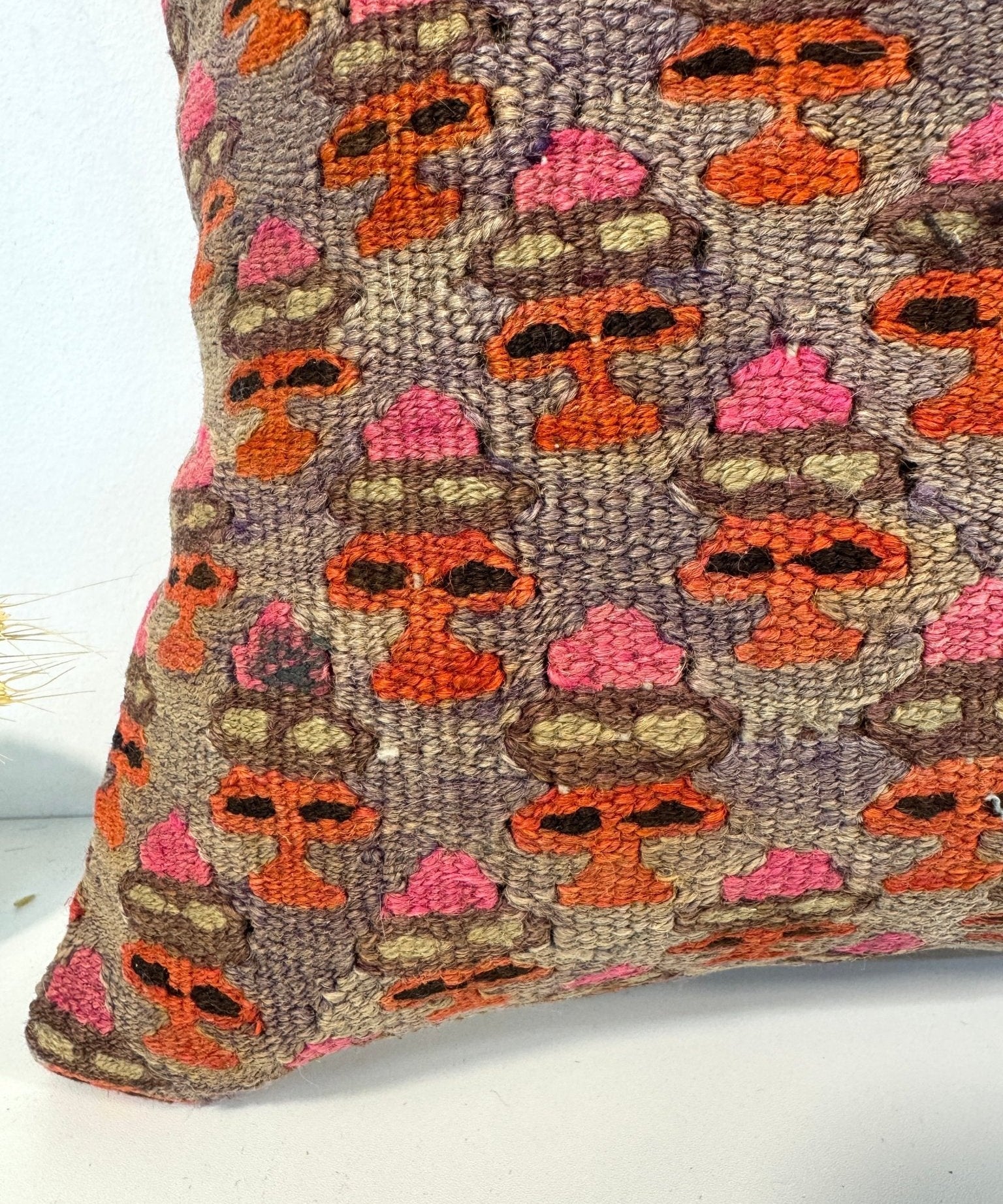 16x16 square pillow with multicolor geometric stitched pattern, angled view