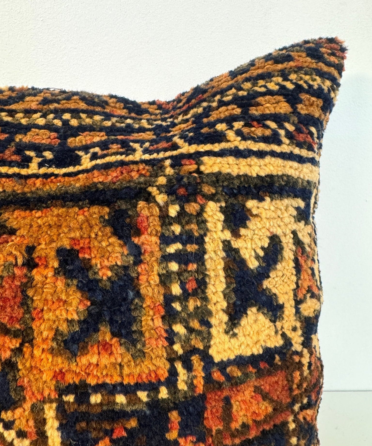 Decorative throw pillow, 18x18, side close-up of multicolor geometric woven fabric in navy and orange