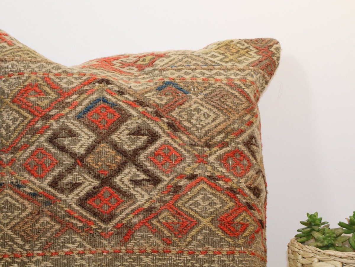 Pillow corner with woven geometric diamond pattern in red, blue, and tan