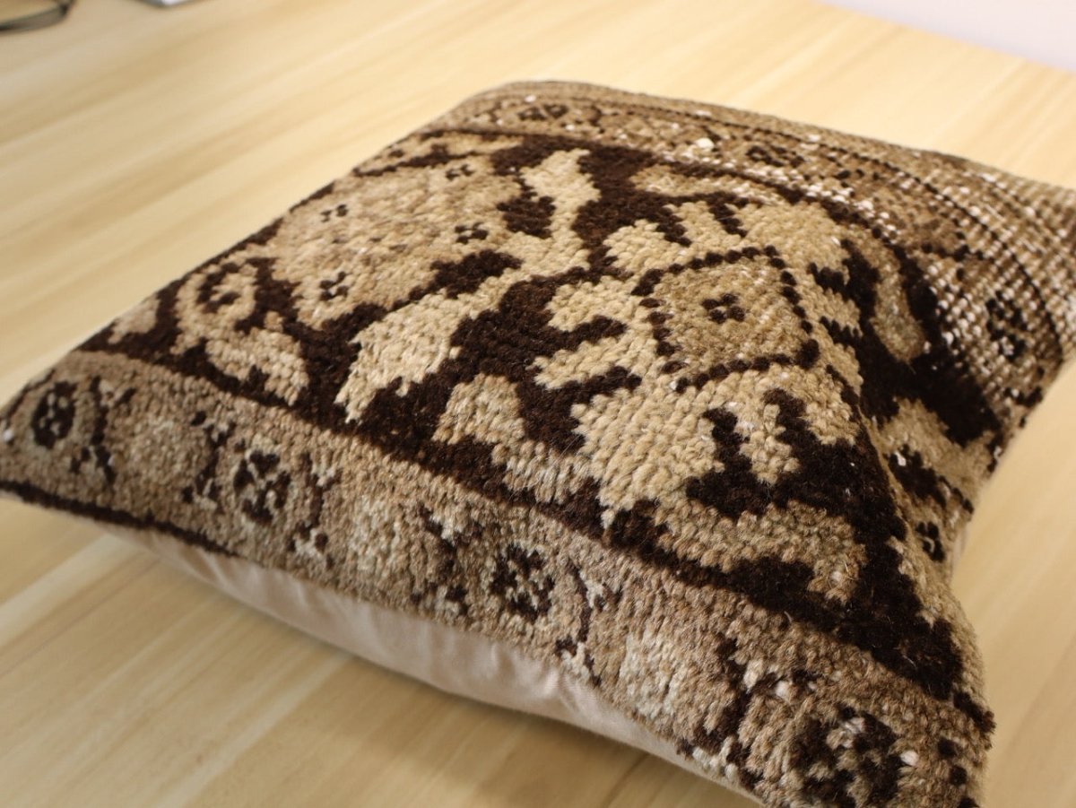 16 x 16 decorative pillow with brown-and-cream patterned cover, laid on side
