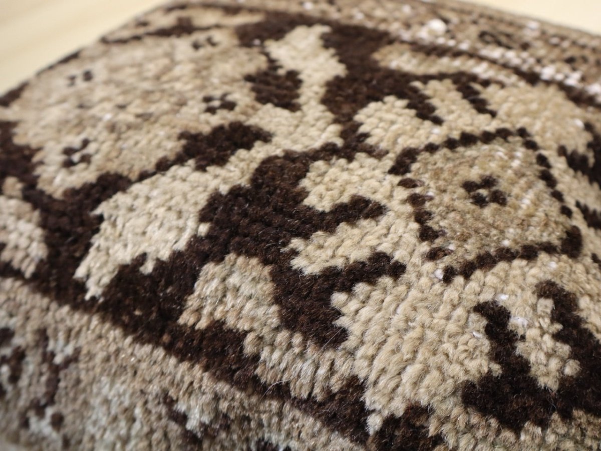 Decorative pillow cover with textured brown-and-cream geometric pattern, close-up