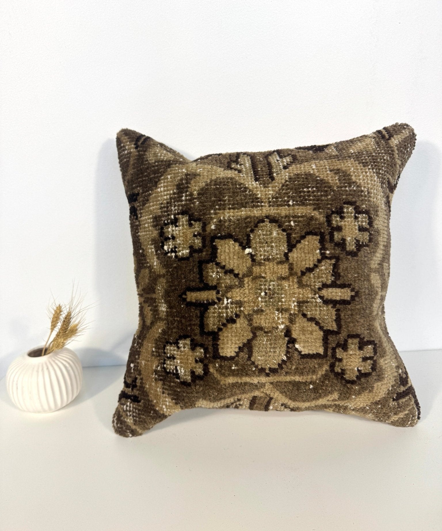 Square throw pillow with gold and dark abstract floral sequin-like pattern