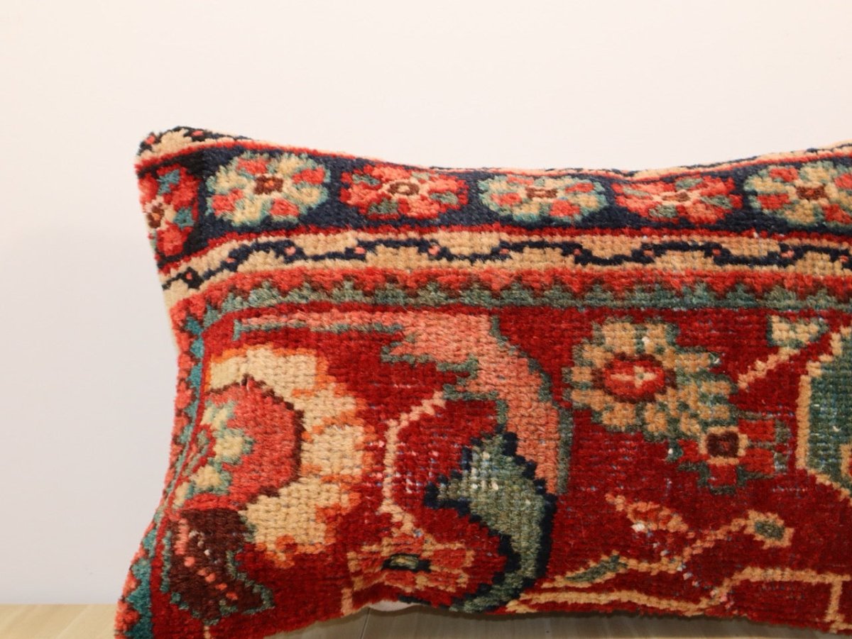 Multicolor patterned pillow cover with red, navy, teal, and beige motifs