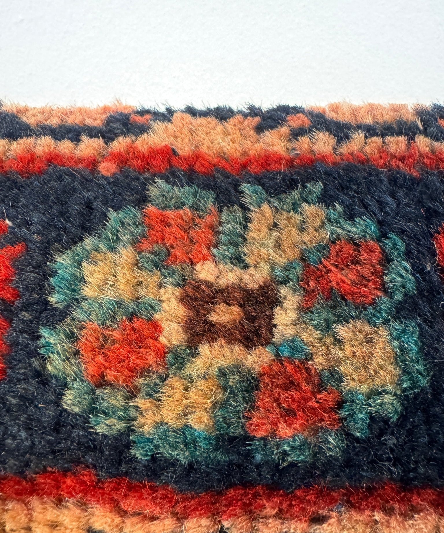 Close-up of multicolor woven fabric with floral motifs and navy border