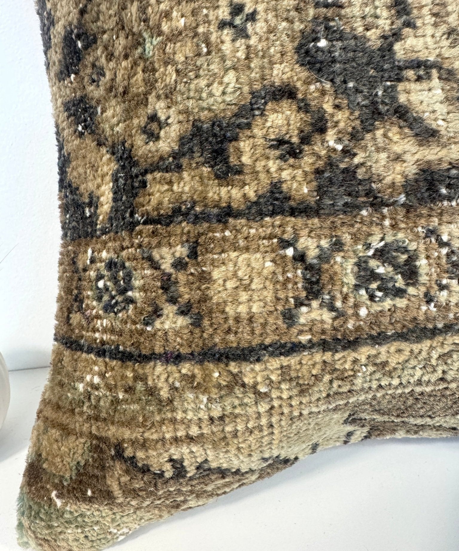 Square decorative pillow with olive-brown woven fabric, dark and cream horizontal bands