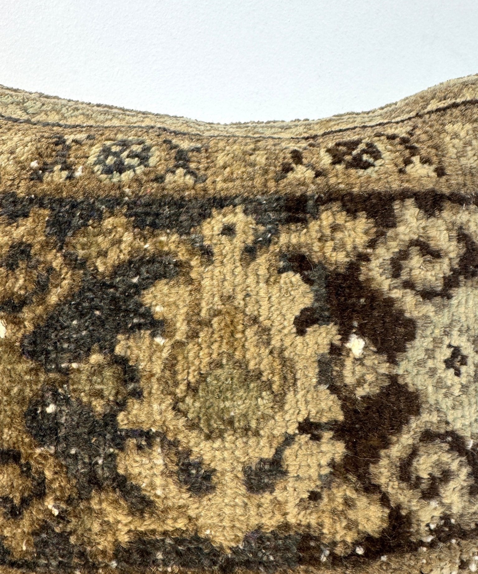 Square decorative pillow front close-up showing olive, cream, and black textured pattern