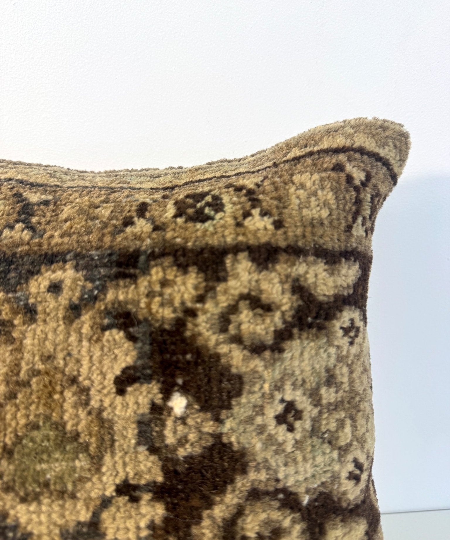 Square decorative pillow front close-up with olive and black geometric motif fabric