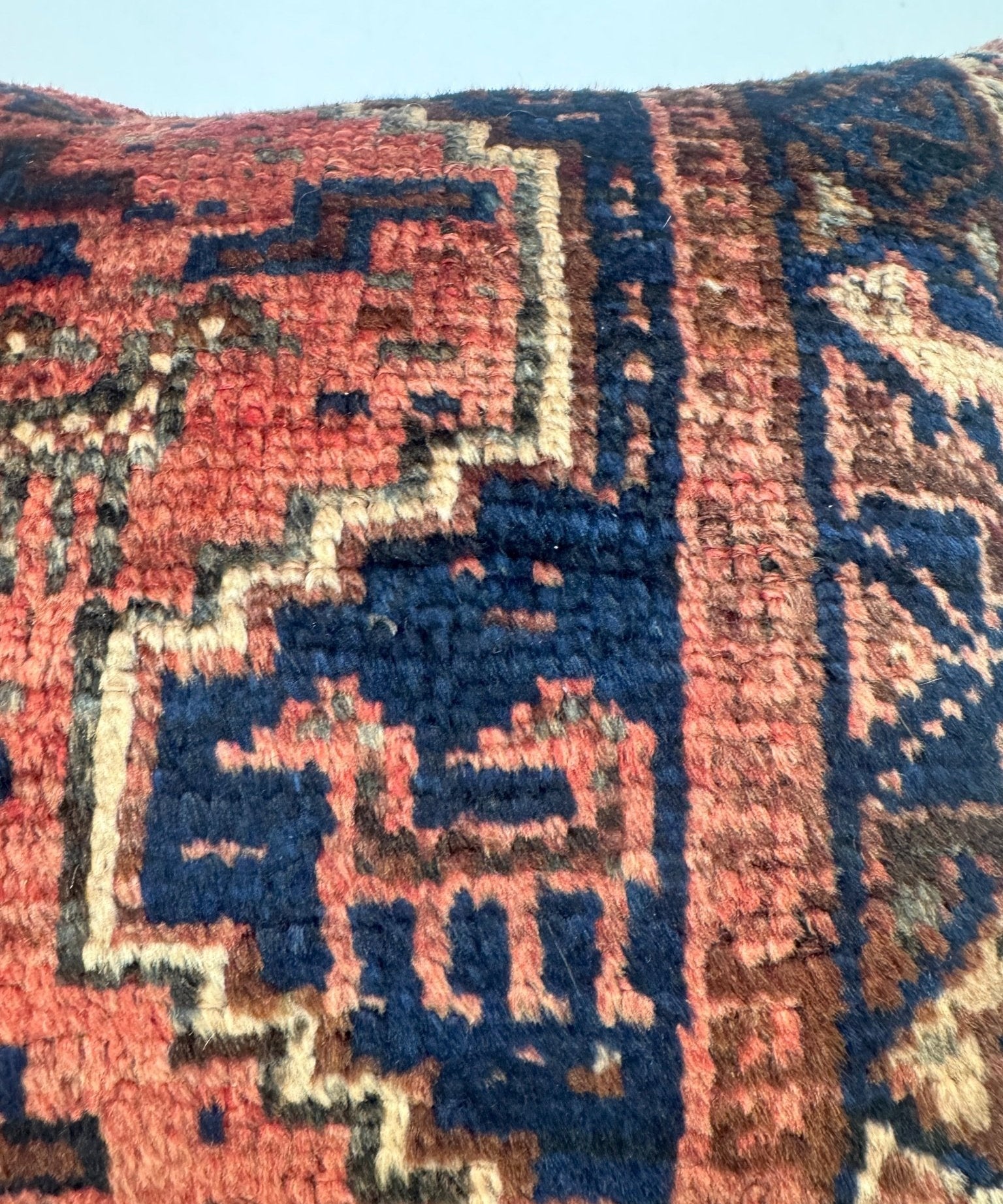 Decorative 18x18 pillow with navy and red geometric weave detail