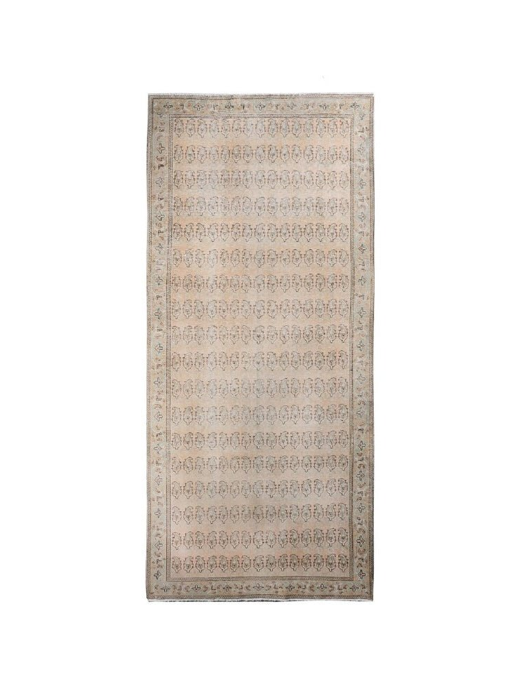Rectangular beige paisley rug with central field of repeating motifs and patterned border