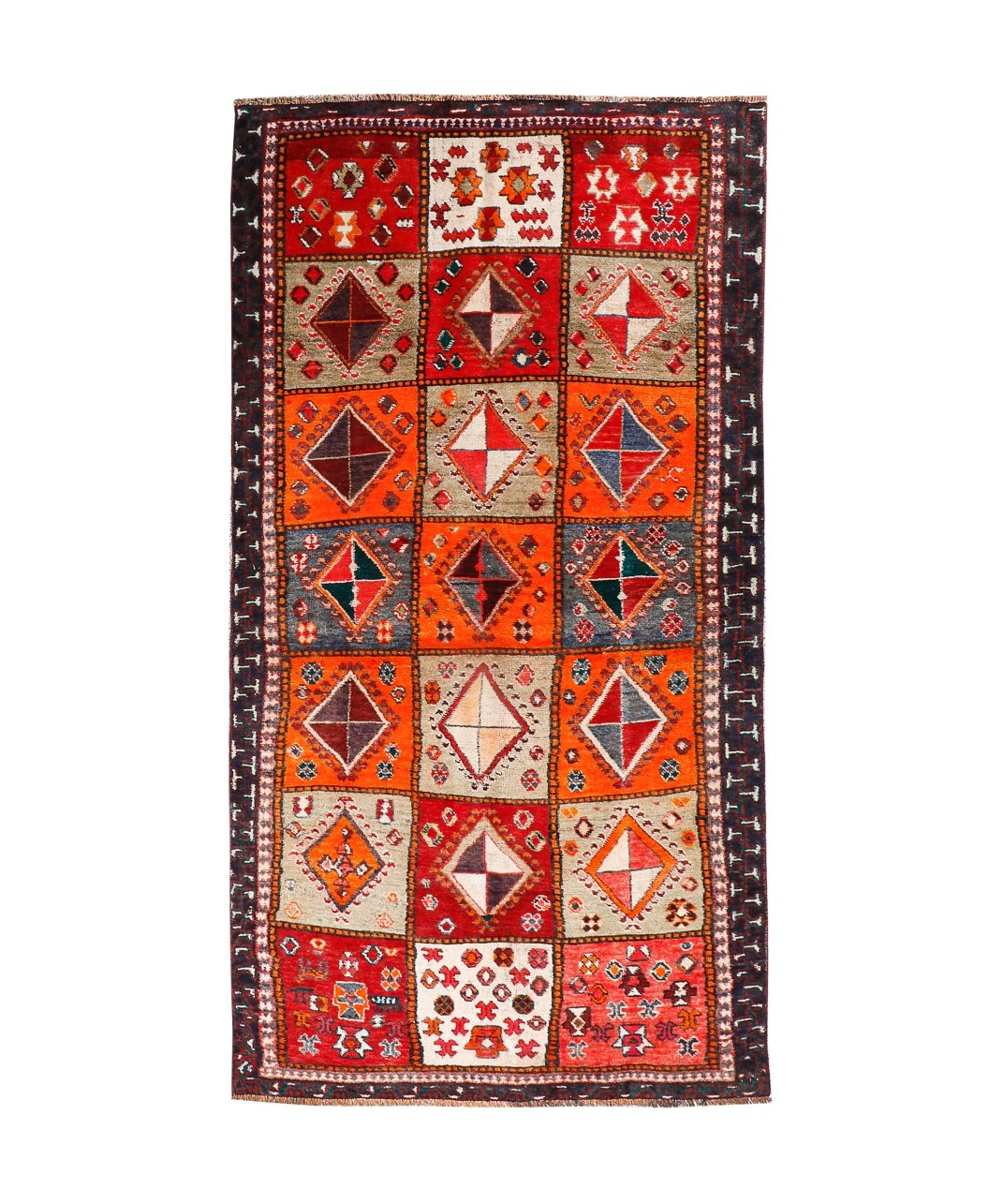 Persian Shiraz rug with red-orange field, cream diamonds, navy border and fringe.