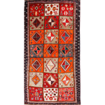 Persian Shiraz rug with red-orange field, cream diamonds, navy border and fringe.