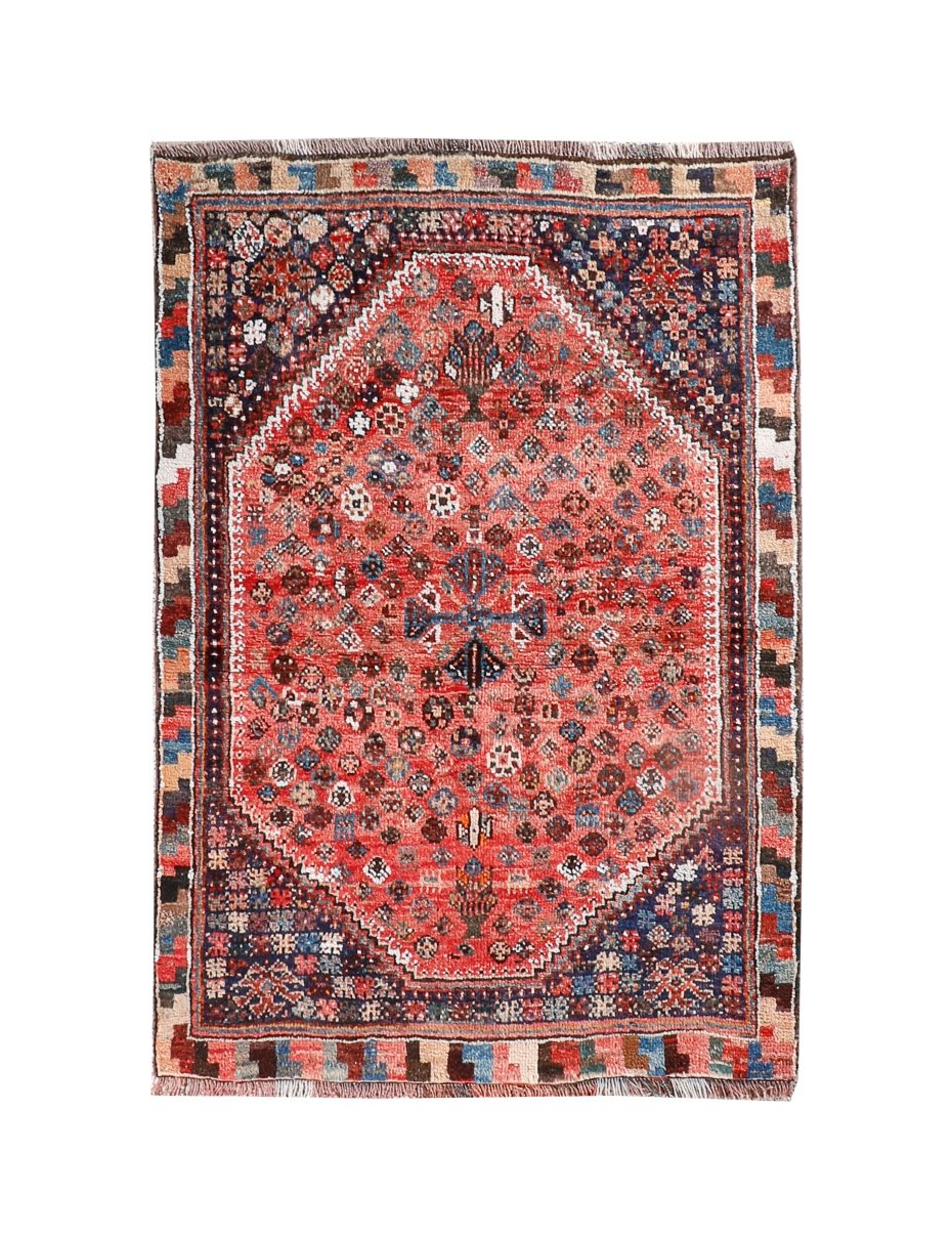 Persian-style rug with red medallion center, blue accents, and geometric border in dark tones
