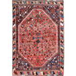Persian-style rug with red medallion center, blue accents, and geometric border in dark tones