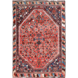 Persian-style rug with red medallion center, blue accents, and geometric border in dark tones