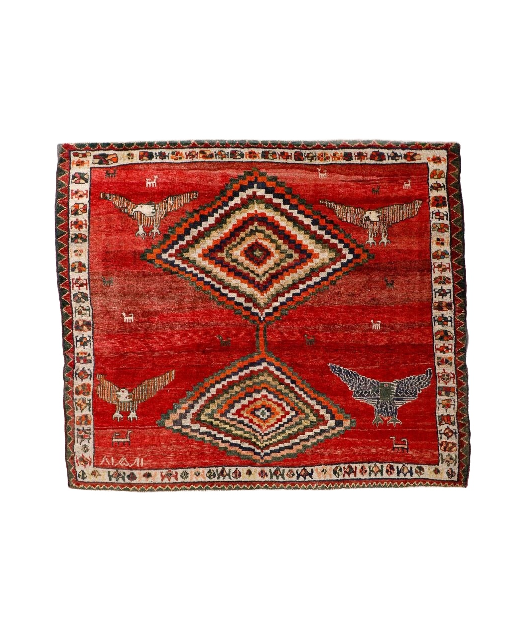 Red Persian-style rug with diamond medallion, birds, and multicolor border design.