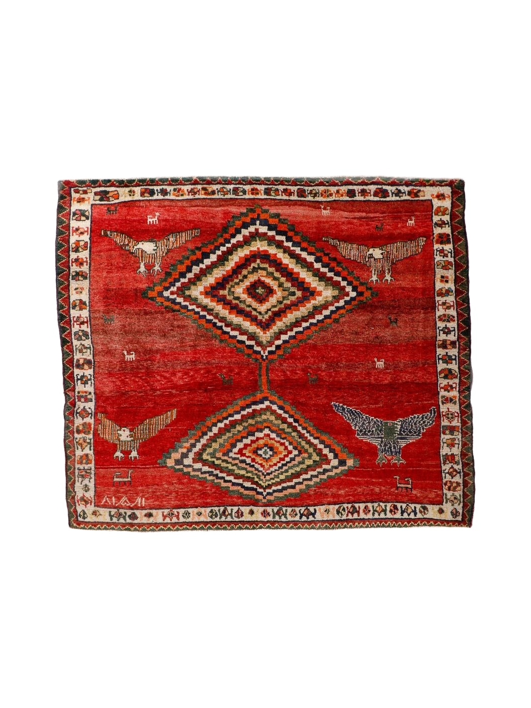 Red Persian-style rug with diamond medallion, birds, and multicolor border design.