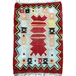 Turkish kilim rug with red background, geometric diamonds, and zigzag border