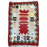 Turkish kilim rug with red background, geometric diamonds, and zigzag border