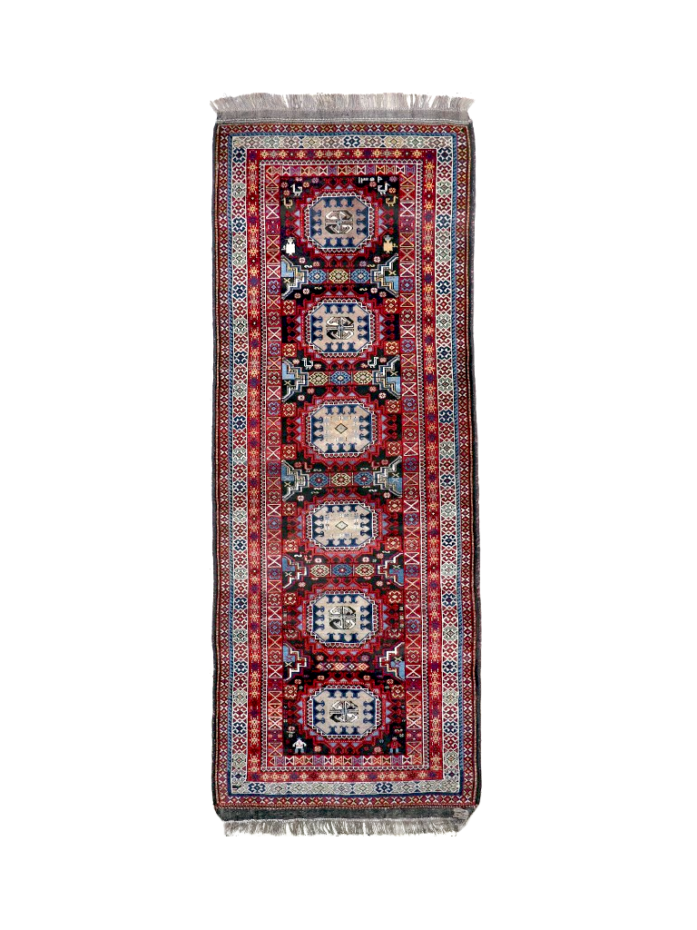 Semi-antique runner rug with red, blue and cream geometric medallion pattern