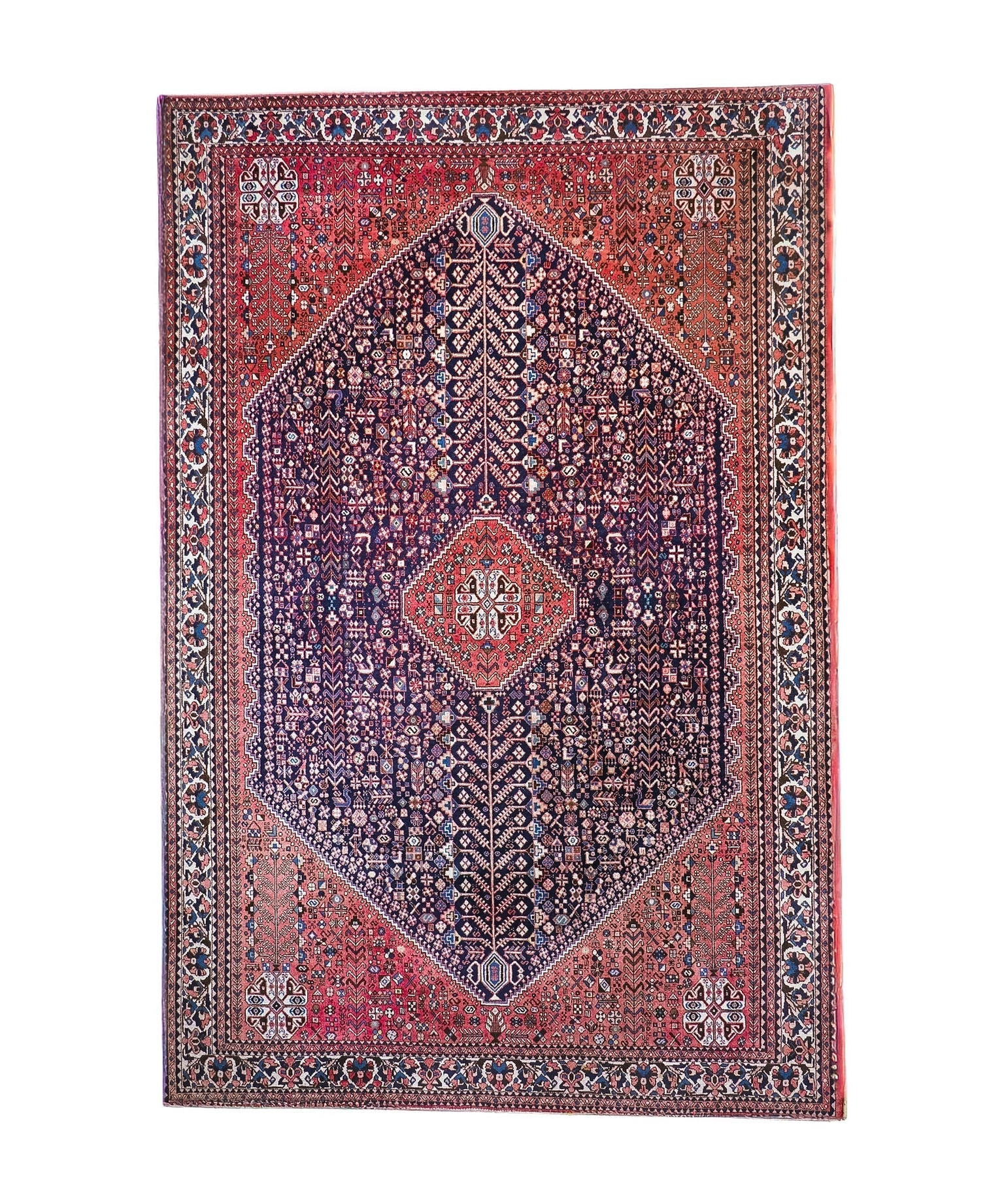 Full view Persian-style rug with red border, navy center, and diamond medallion